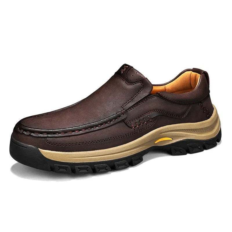 Men's black leather mountaineering shoes with thick rubber soles and round toe on a neutral background.