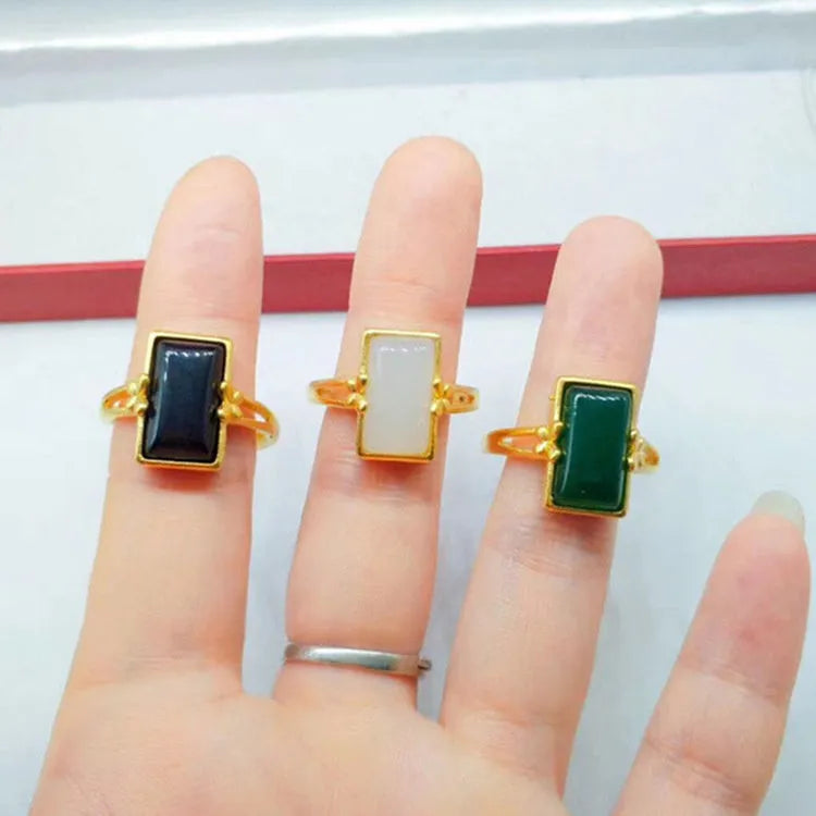 Adjustable gold-plated brass ring with a long coloured gemstone in green, white, or black.