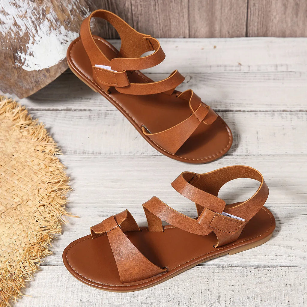 Women's flat sandals with Velcro strap, round toe, and PU upper in colourful, brown, or black.