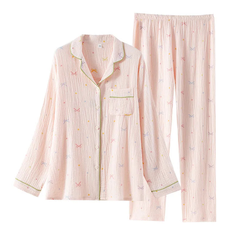 Women's beige long sleeve cotton pajama top and trousers set laid flat.