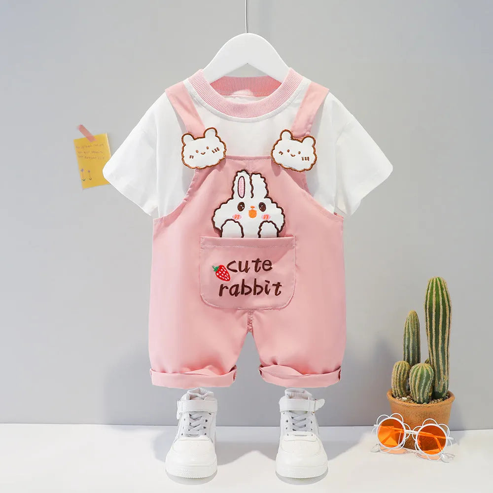 Yellow cotton baby romper with cartoon print and openable shoulder straps, laid flat.