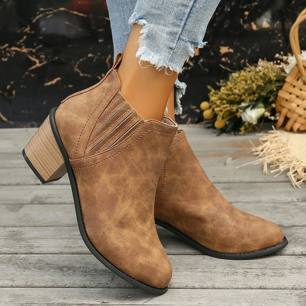 Black women's ankle boots with a pointed toe, thick square low heel, and slip-on design on a white background.