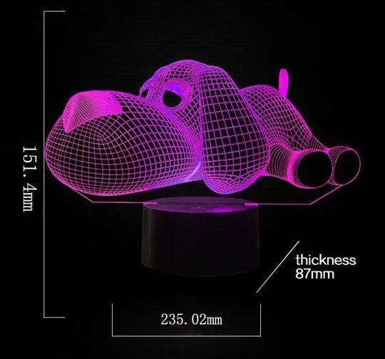 Dog-shaped 3D desktop lamp glowing in multiple colours on a wooden surface.