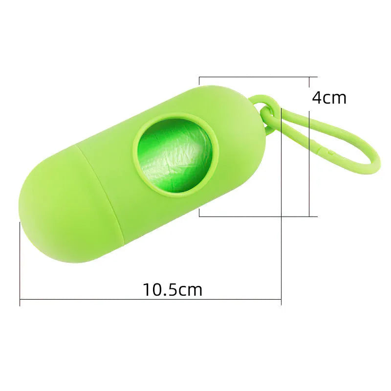 A small black plastic dog poop bag holder with a hook and Velcro strap, shown next to a roll of bags.