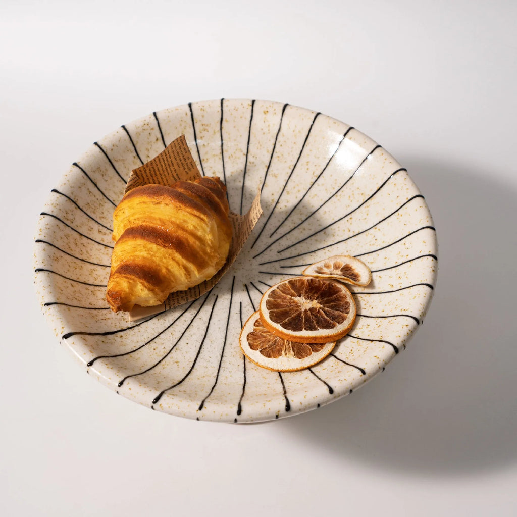 Black and white striped retro-style resin fruit or dessert plate on a table.