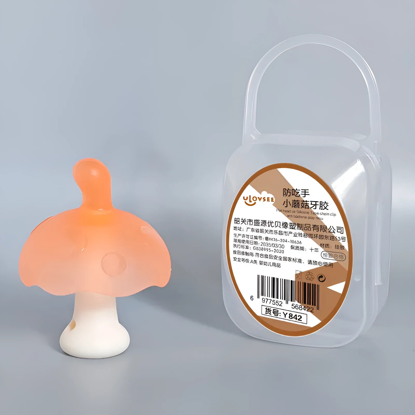 Small mushroom-shaped pink chewing gum inside a transparent box with a silver chain attached.