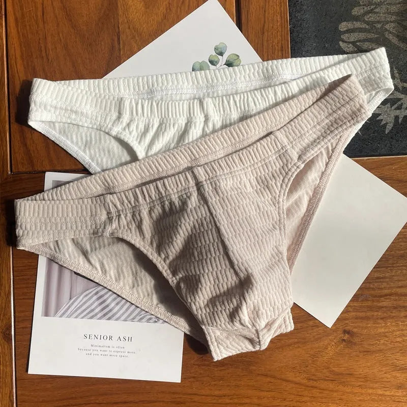 Men's solid colour cotton briefs with mid waist and triangle style in apricot black and skin colour.