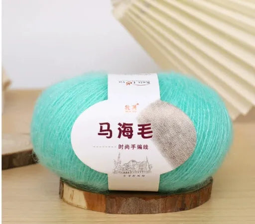DIY mohair scarf weaving kit showing one wool ball and a selection of 34 colour options including white, pink, blue and green.
