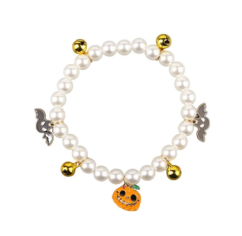 Purple simulated pearl cat collar with three Halloween pumpkin charms: ghost, skull, and smiley face.
