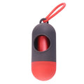 A small black plastic dog poop bag holder with a hook and Velcro strap, shown next to a roll of bags.