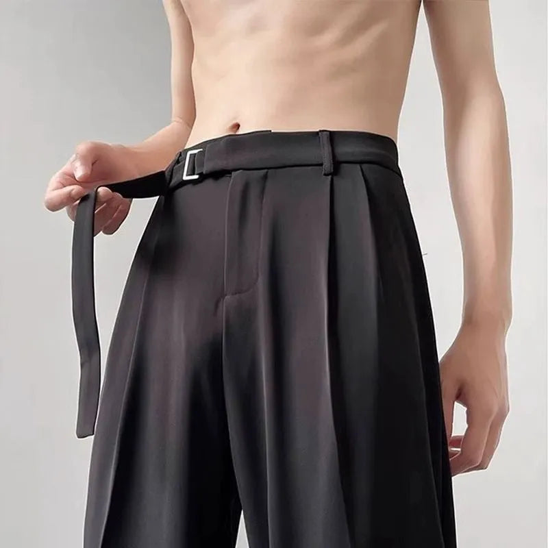 A pair of thin, black wide leg trousers with a straight cut and loose fit, laid flat.