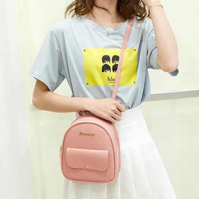 Small black PU leather women's shoulder backpack with zip, shown as a letter-style purse.