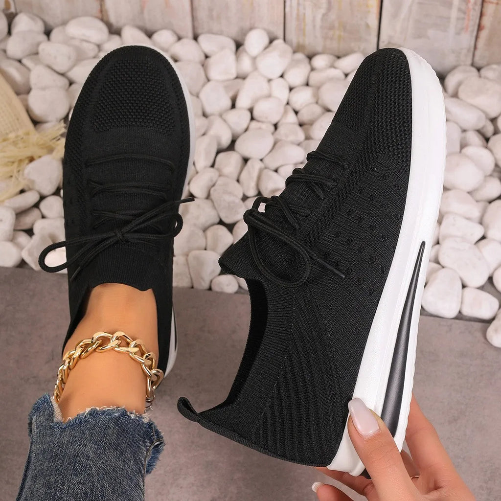 Women's low-top red fly-knit sneakers with round toe and lace-up front on a white background.