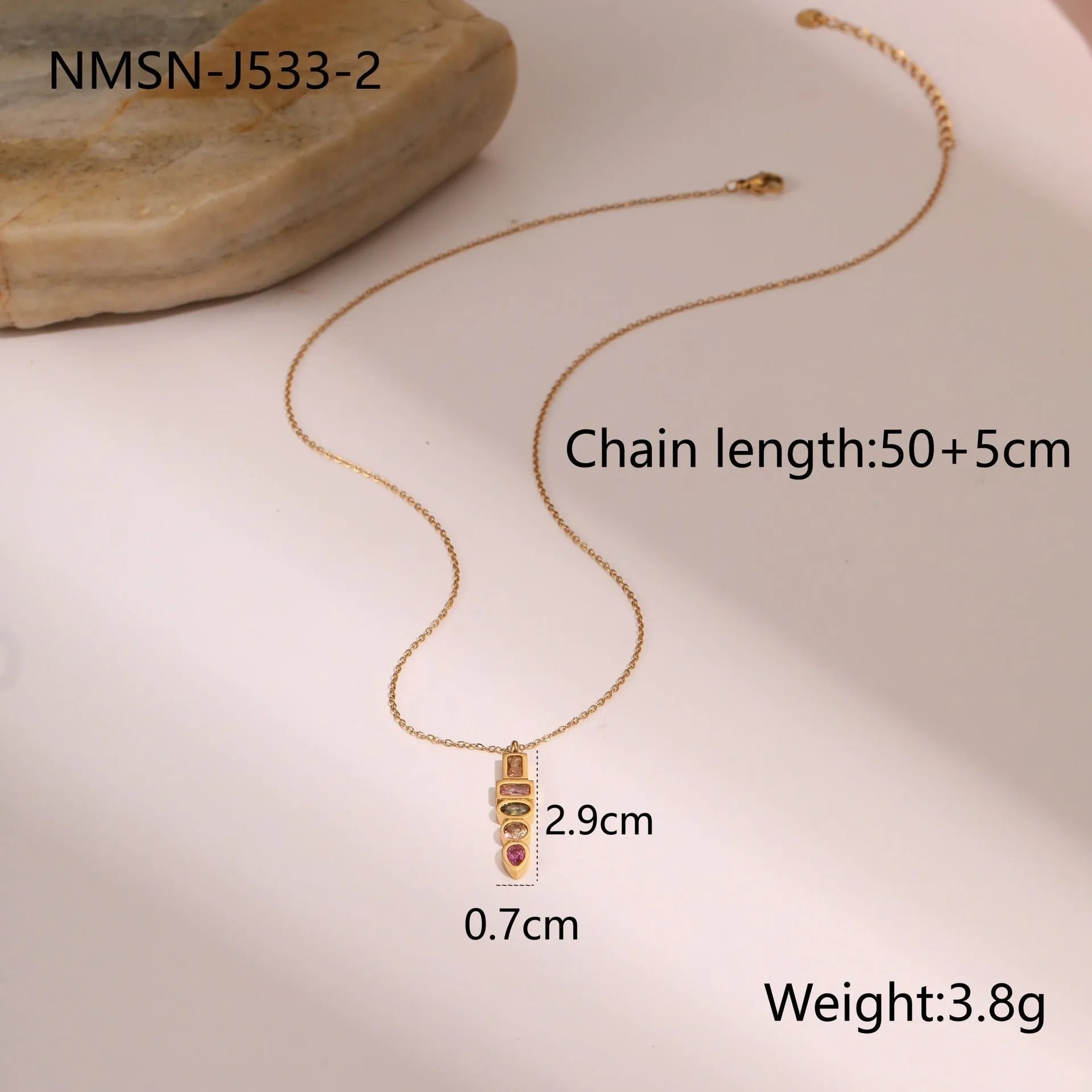 Geometric gold-plated necklace, ring, and earrings set with an adjustable chain on a grey background.