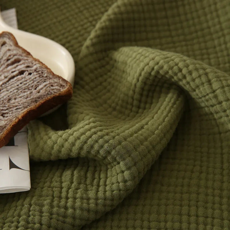 Four-layer gauze cotton blanket with knotted tassels in avocado green colour
