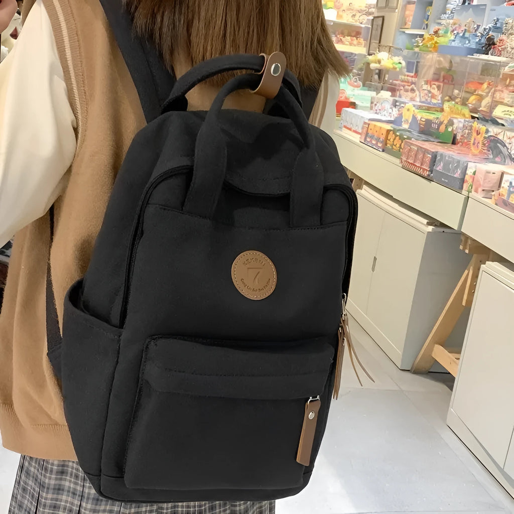 Black Oxford cloth retro-style backpack with curved shoulder straps and sewing thread details