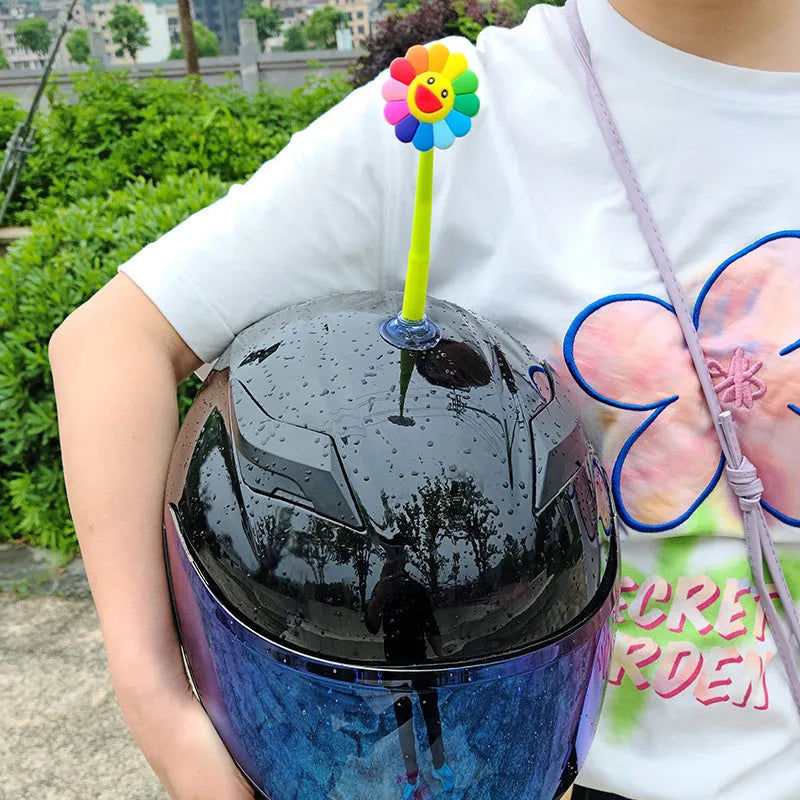 Yellow silicone sunflower decoration with suction cup for attaching to a helmet.