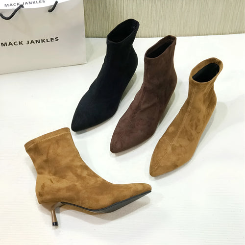 Black pointed toe ankle boots with a stiletto heel on a plain background.