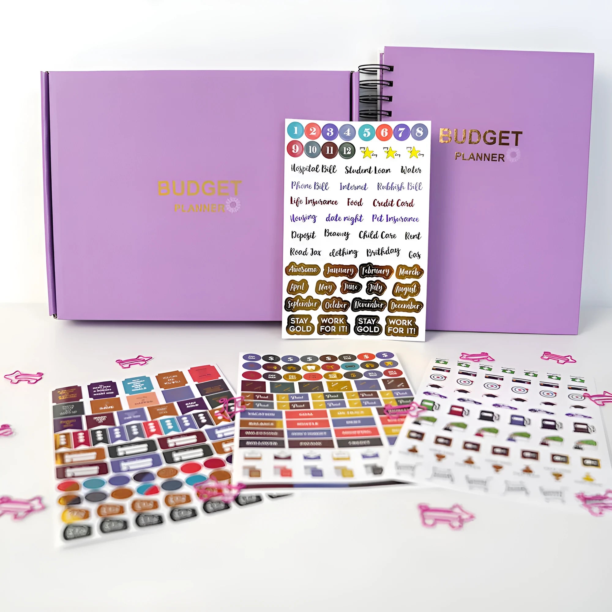 J12 purple coil-bound financial planning notebook with pen, stickers, and paper clips