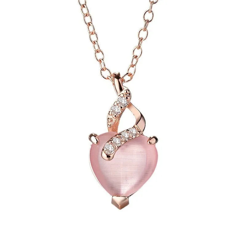 Rose gold heart-shaped pendant necklace with a pink synthetic crystal centre on a matching cross chain.