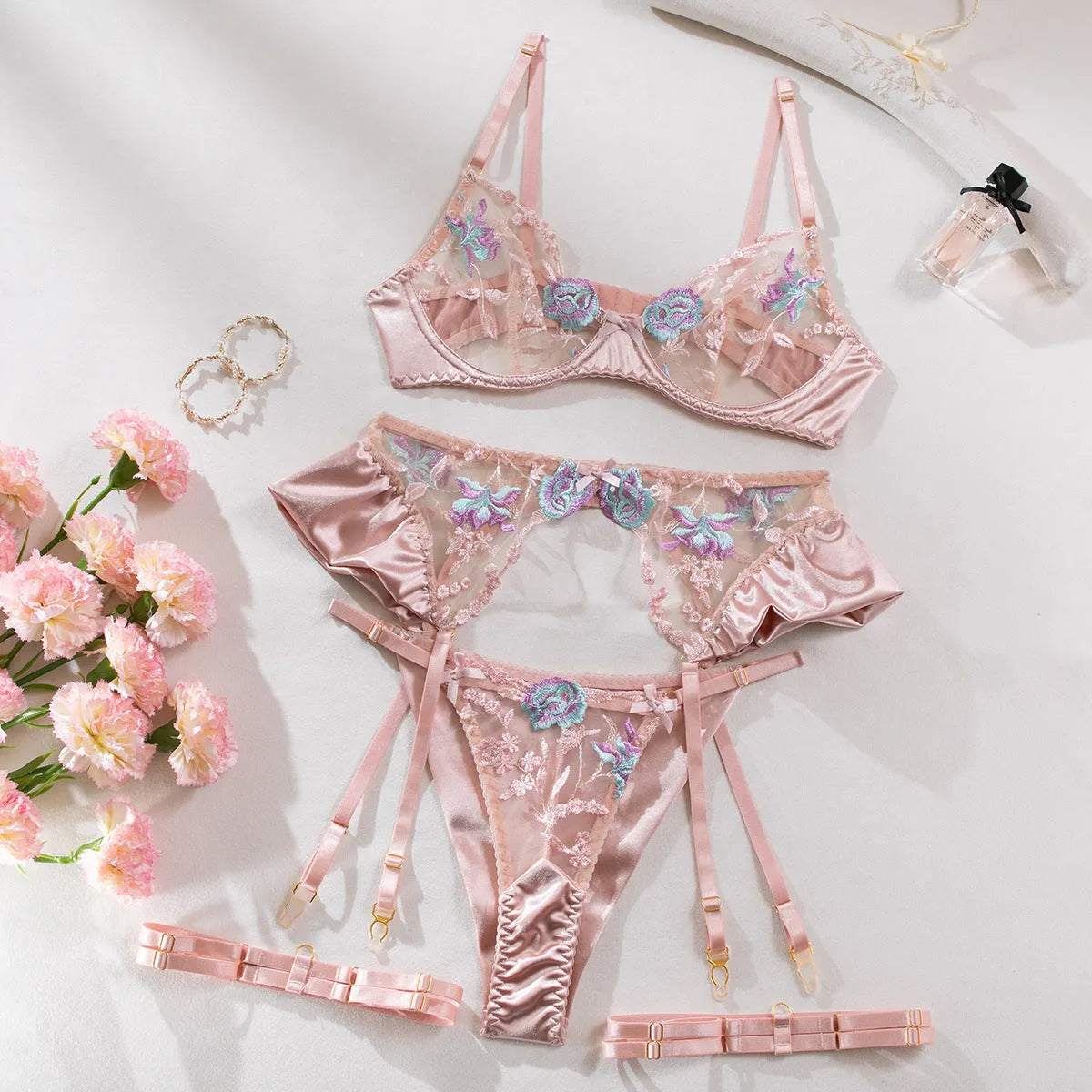 Light purple satin lingerie four-piece set with white embroidery detailing on a mannequin