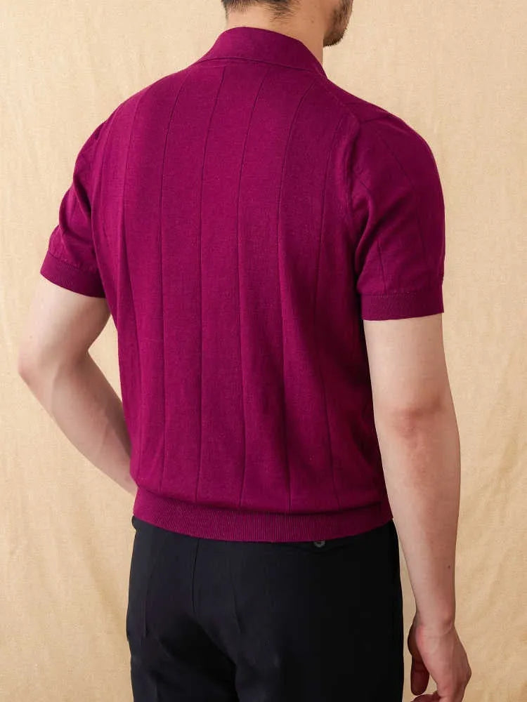 Man modelling a purple short sleeve polo shirt with a sunken stripe knit pattern and a seagull collar.