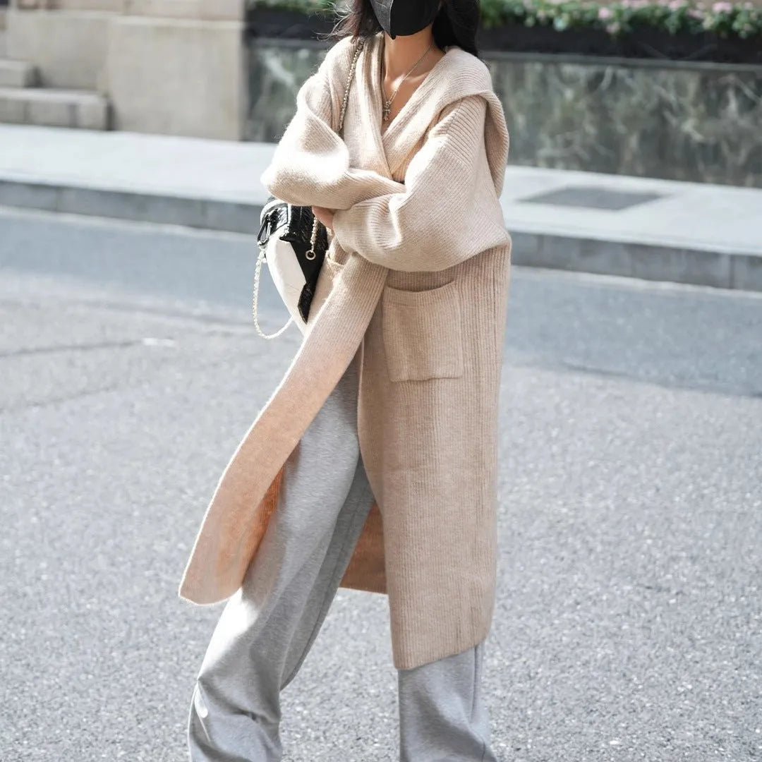 Long grey knitted women's cardigan trench coat with a hood and long sleeves.