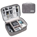 Black waterproof travel cable organiser bag open to show removable dividers and mesh pockets for electronics.