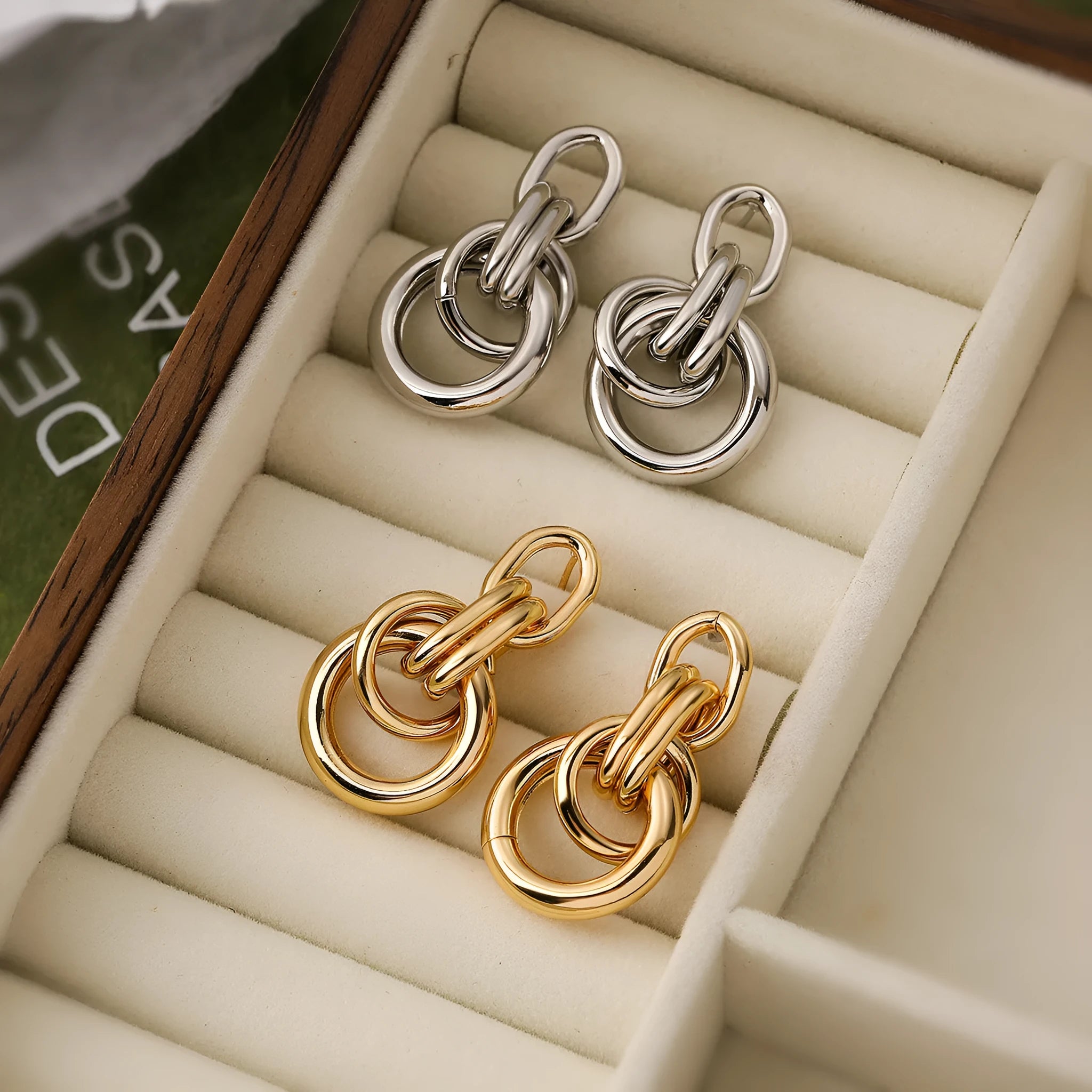 A pair of gold-toned geometric drop earrings with an irregular shape, made from copper.