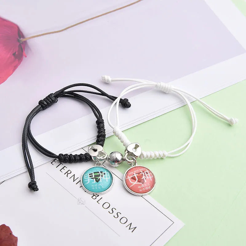 Pair of magnet couple bracelets with suction clasp on wrist, showing alloy designs like crown and love lock.
