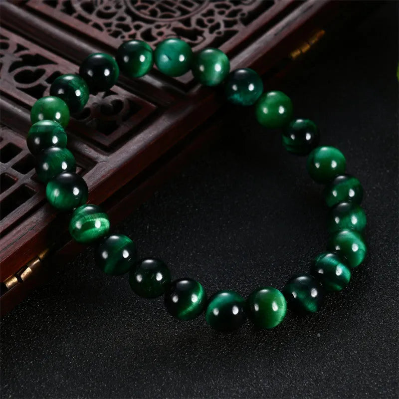 Polished green tiger eye stone bracelet with geometric beads in various sizes on wrist