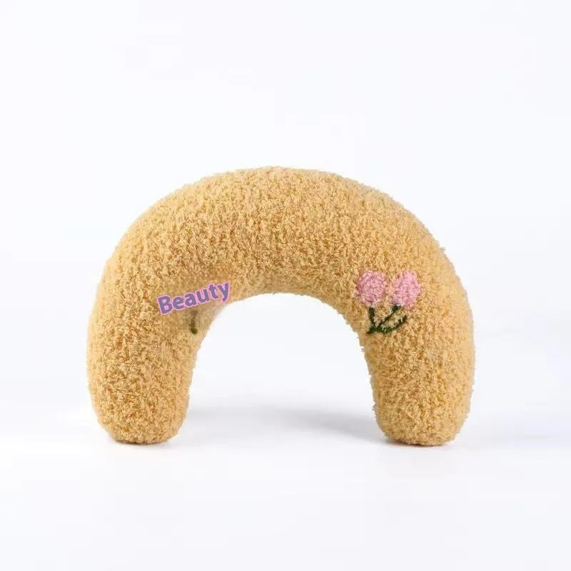 Blue moon-shaped and yellow question mark-shaped cloth pillows for cats, showing U-shaped neck support design.