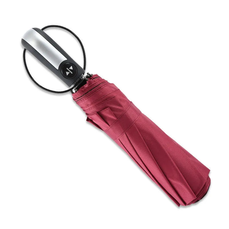 Large black triple folding automatic business umbrella with a steel frame and rubber handle, shown open.