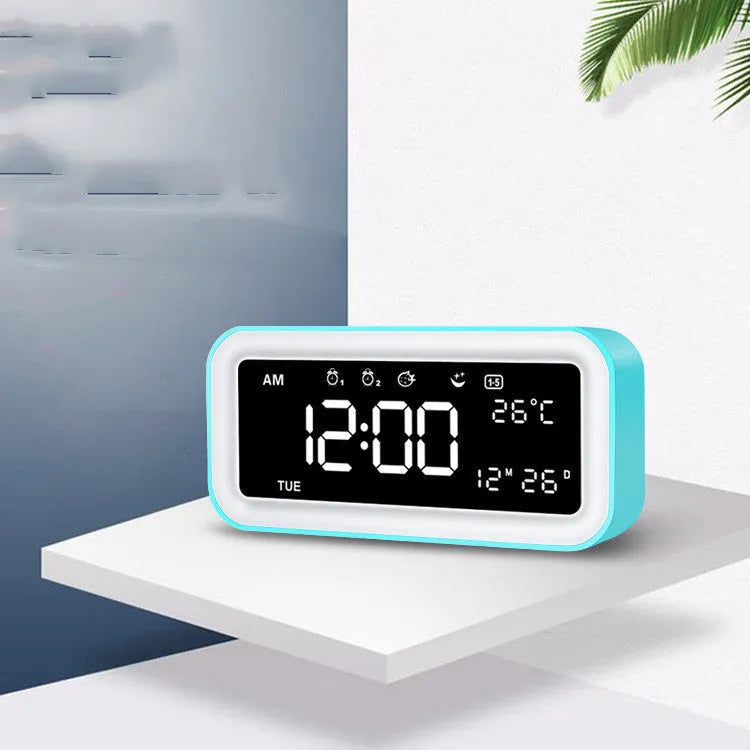 Blue rectangular LED atmosphere light alarm clock with digital display on a desk.