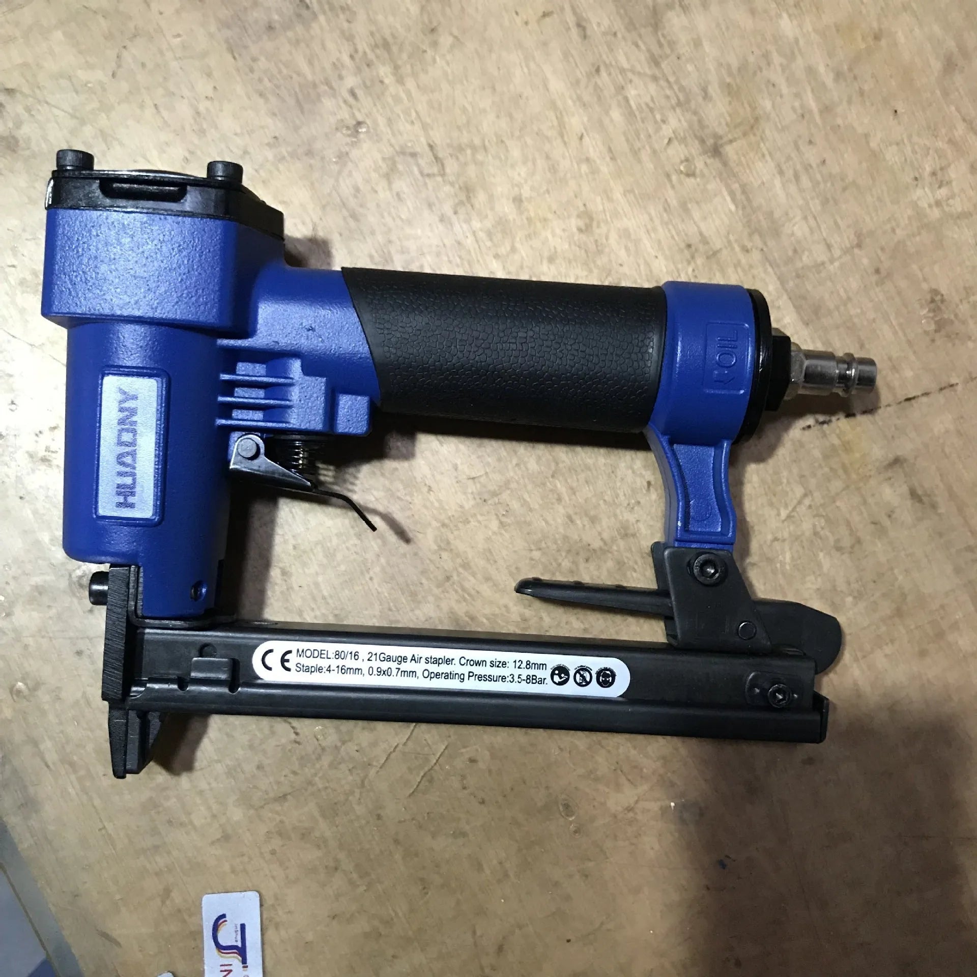 Blue and yellow U-type pneumatic strip nail gun with American connector for furniture and interior work.