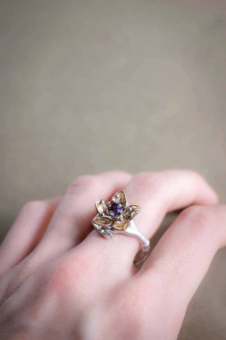 Silver and rose gold two-tone floral design alloy ring on a geometric band.