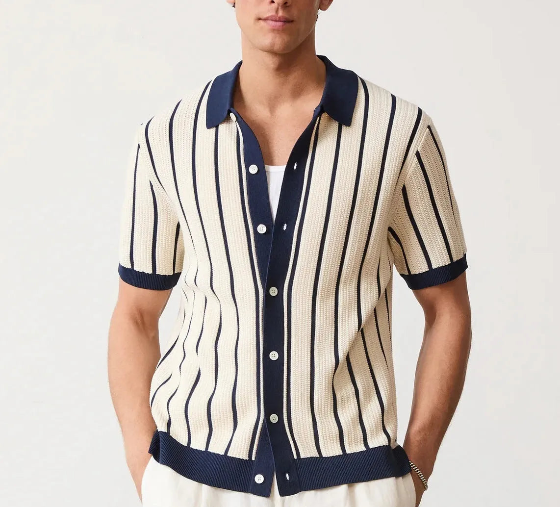Men's white short sleeve knitted shirt with an asymmetric lapel, laid flat.