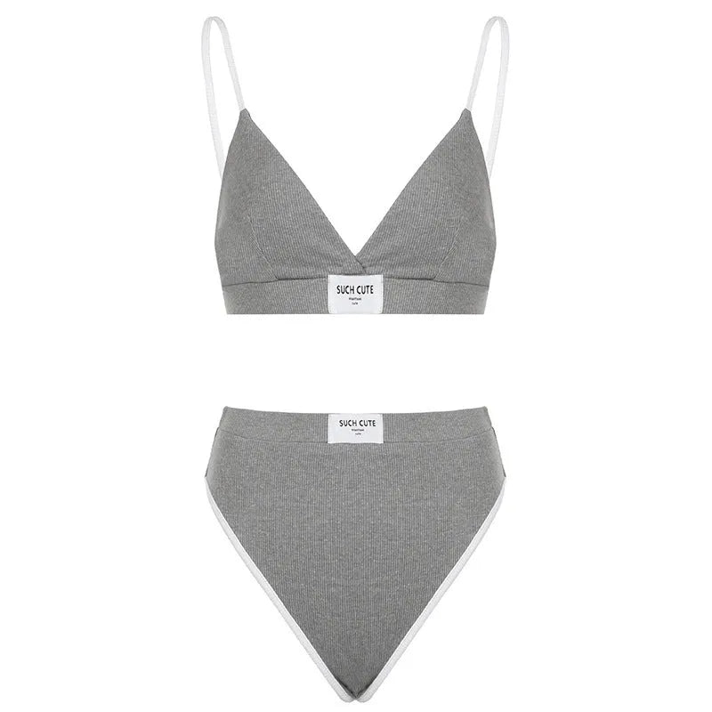 Women's black bikini set with contrast binding and embroidered lettering on a sleeveless top and shorts.