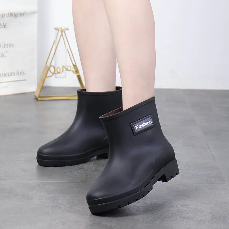 Women's black PVC rain boots with mid-calf height and low heel