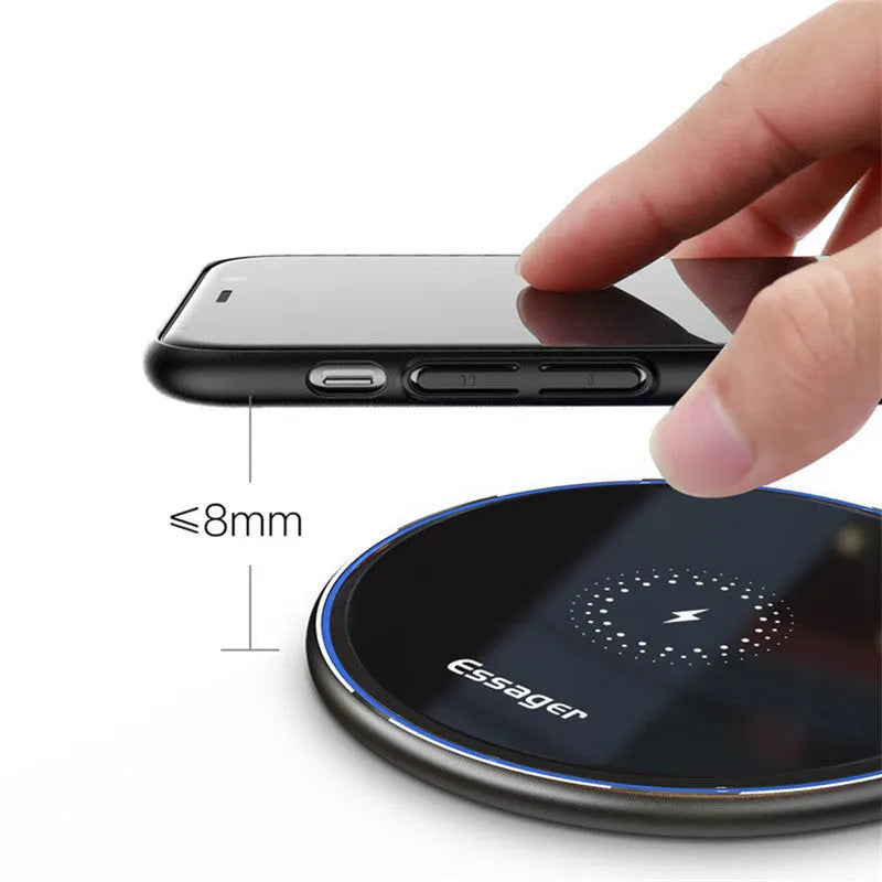 Black 15W fast wireless charging pad with LED indicator light on a desk