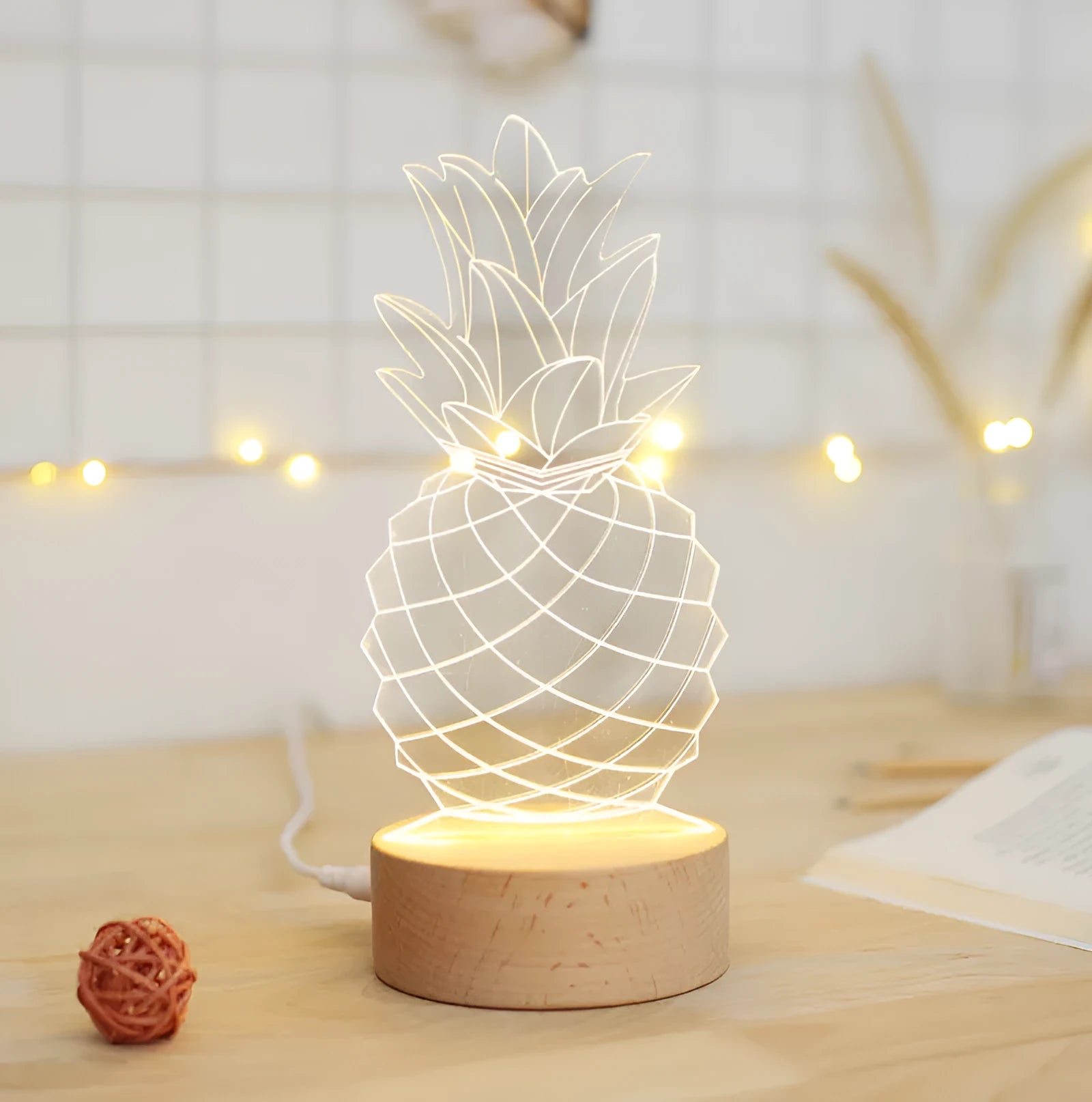 Cartoon pineapple-shaped USB night light with wood and acrylic casing on a table.