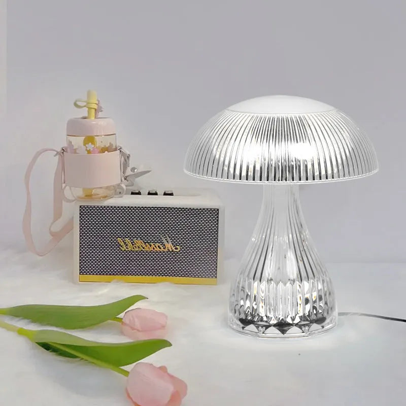 White rechargeable touch control bedside lamp with acrylic shade on a table.