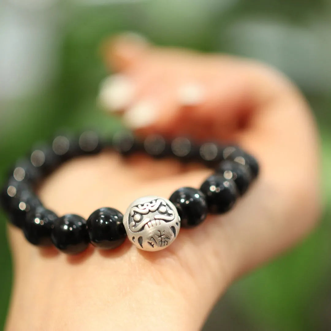 Close-up of a women's bracelet with large black agate beads and sterling silver, showing Chinese style design.