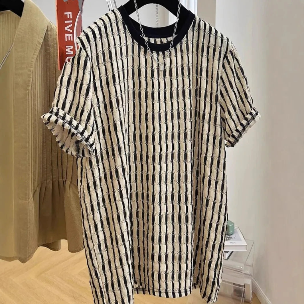 Man wearing a black and white striped loose casual short sleeve shirt made from linen and silk blend.