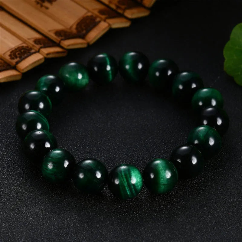 Polished green tiger eye stone bracelet with geometric beads in various sizes on wrist