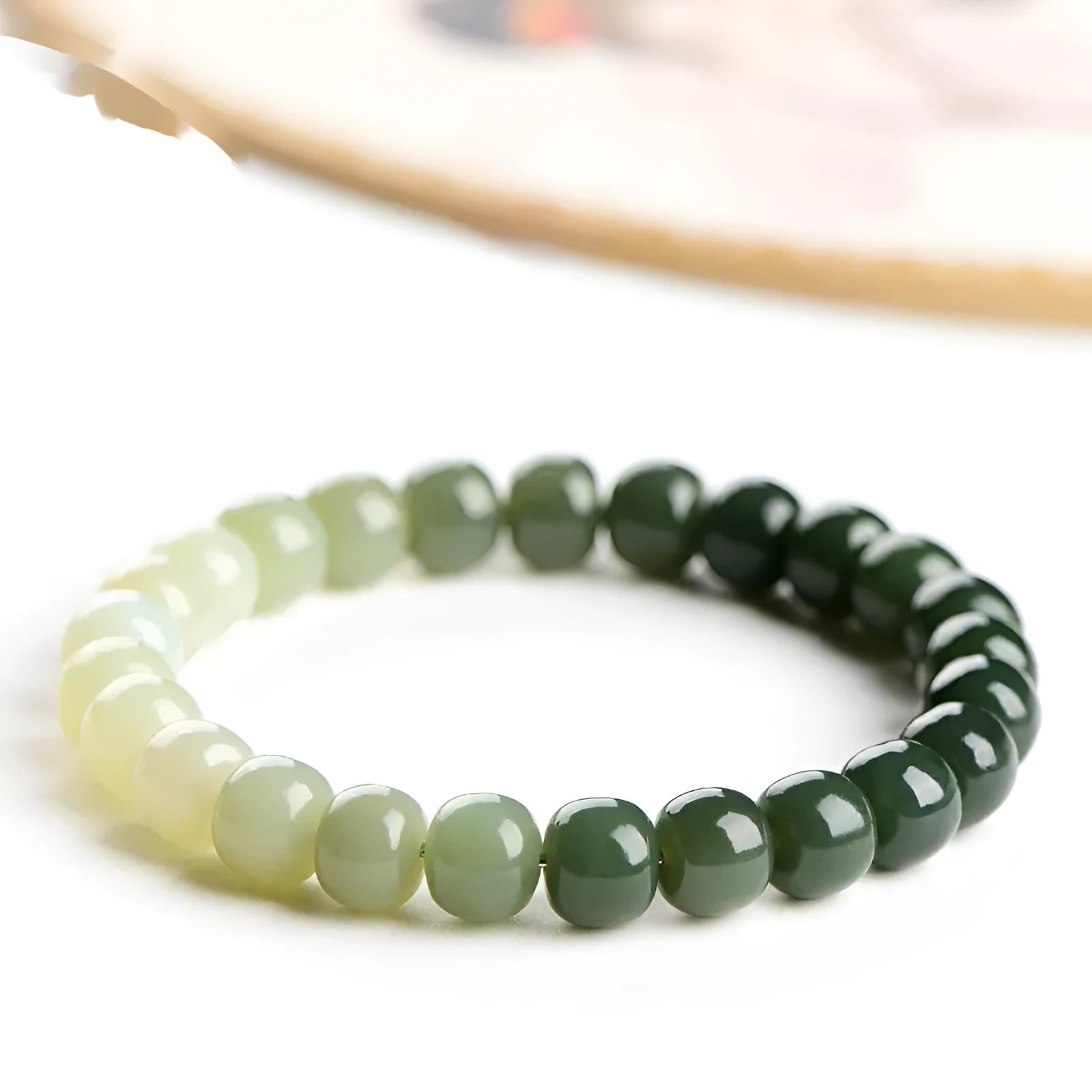 Natural Hetian jade bracelet with gradient clear water coloured beads on a wrist.