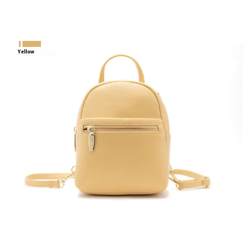 Soft black PU mini backpack with front pockets, shown open to reveal internal mobile phone sleeve and zipper compartment.