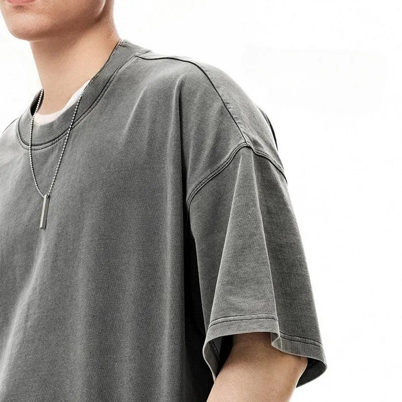 Man wearing a vintage washed khaki cotton t-shirt with loose fit and drop-shoulder sleeves.