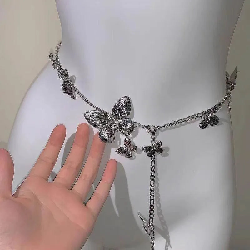 Gold and silver butterfly motif waist chain jewellery belt for women on a plain background.