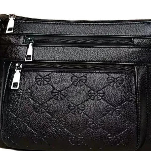 Women's black PU leather crossbody shoulder bag with embossed pattern and phone pocket